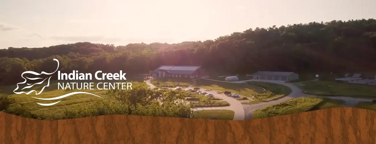 Aerial view of Indian Creek Nature Center campus showing main building, grounds, and surrounding wooded landscape