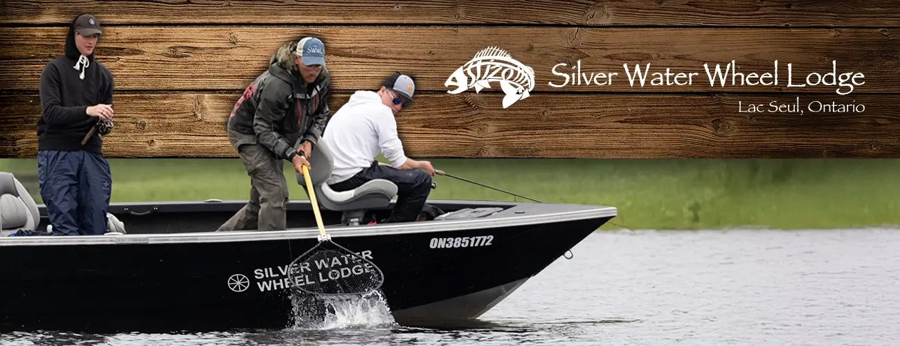 Three people fishing from a Silver Water Wheel Lodge boat on a lake in Lac Seul, Ontario